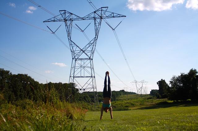 A woman stands in her arms in a field