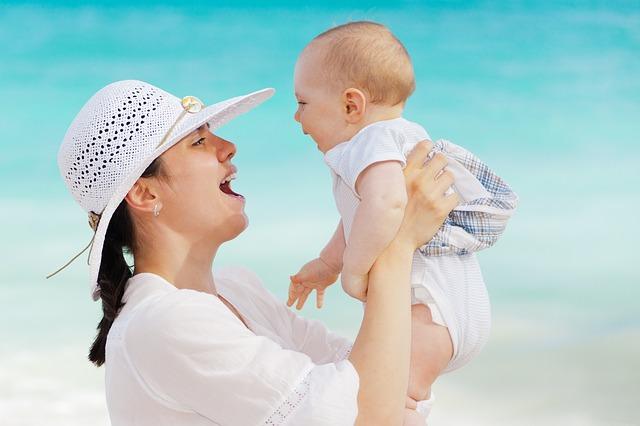 Joyful mom holds the baby