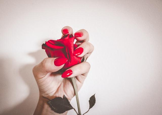 Woman holds a rose in her hand